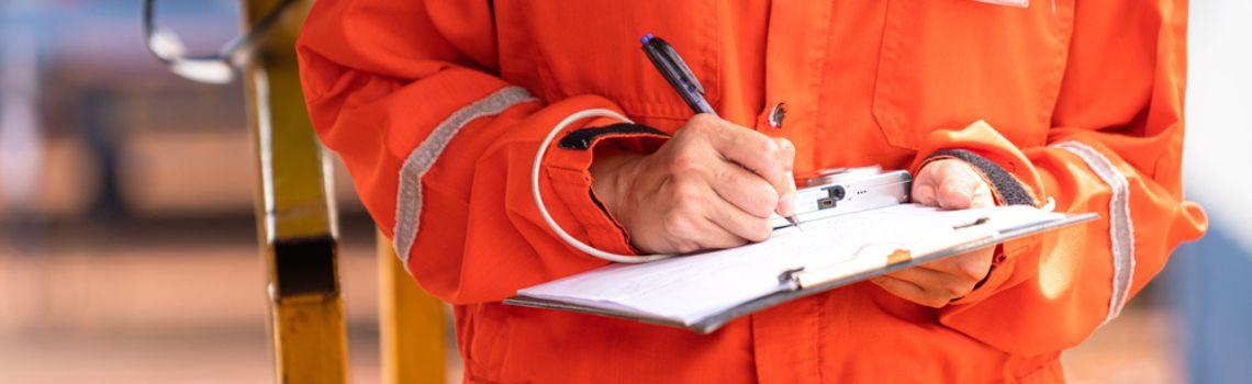 Person in high vis jacket with pen and clipboard