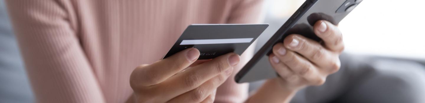 Woman holding mobile phone and credit card to confirm online purchase